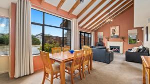 a dining room with a table and chairs and a fireplace at Heritage Village - Villa #5 in Wanaka