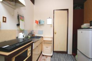 a small kitchen with a sink and a refrigerator at Kazenooka in Motobu