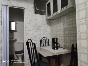 cocina con mesa con sillas y licuadora en Recanto, en Mongaguá