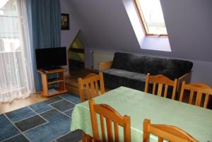 una sala de estar con una mesa y un sofá en Pokoje i Apartamenty u Architekta, en Czarna Góra