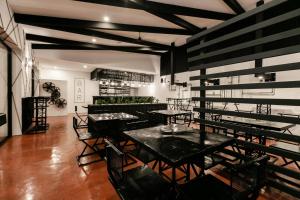un restaurant avec des tables et des chaises noires dans une salle dans l'établissement D' LA TORRE HOTEL, à Managua