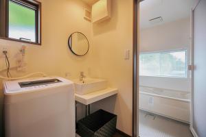 a bathroom with a sink and a washing machine at Villas Asama no Iori in Fujiyoshida