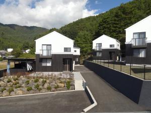 Une maison avec des montagnes en arrière-plan dans l'établissement ヴィラス浅間の庵, à Fujiyoshida