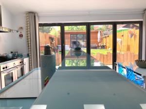 a kitchen with a view of a garden through glass doors at 8 Guests House Wow in Coventry