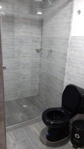 ein Bad mit einem schwarzen WC und einer Dusche in der Unterkunft Apartamento Ynj Bogot in Bogotá