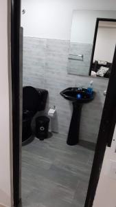 ein Bad mit einem schwarzen WC und einem Waschbecken in der Unterkunft Apartamento Ynj Bogot in Bogotá