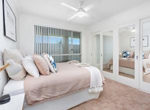 a white bedroom with a large bed and a window at kims@kiama in Kiama