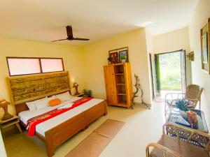 a bedroom with a bed and a chair in it at Nature Care Village- Rajaji National Park in Rishīkesh
