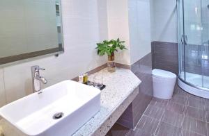 une salle de bain avec un lavabo blanc et des toilettes dans l'établissement Thiên An Hotel, à Hai Phong 12 autres photos