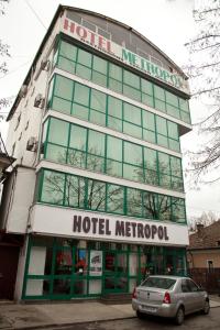 un edificio metropol de hotel con un coche aparcado delante en Hotel Metropol, en Piteşti