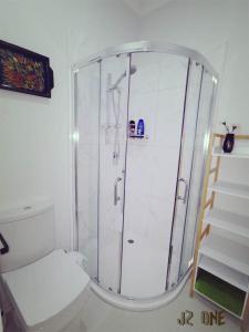 a white bathroom with a shower and a toilet at JZ One in Box Hill