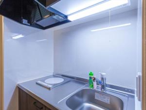 a kitchen with a sink and aaucet at Living Inn Asahibashiekimae Premier in Naha