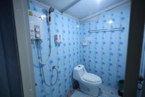 a blue bathroom with a shower and a toilet at Mata Guesthouse in Ko Kood