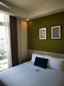 Un dormitorio con una gran cama blanca y una ventana en Scott Hotel KL Sentral en Kuala Lumpur