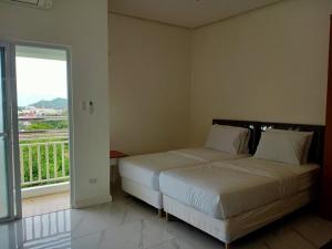 1 dormitorio con 2 camas y ventana grande en Centtro Residences, en Los Baños