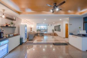 a kitchen and living room with a ceiling fan at Tèja Hotel in Bangkok