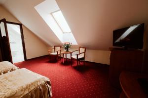een kamer met een tafel met stoelen en een televisie bij Hotel Groman in Sękocin