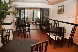 a restaurant with tables and chairs in a room at Hotel Metropol in Piteşti