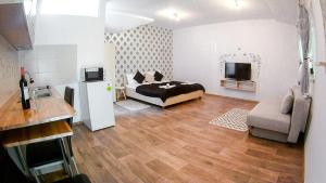 - une chambre avec un lit, une télévision et un canapé dans l'établissement Nice & Cozy Apartments, à Timişoara
