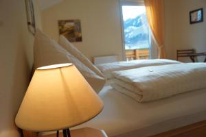 a bedroom with two beds with a lamp and a window at Chalet Olympia in Neustift im Stubaital