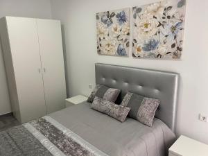 un dormitorio con una cama con dos almohadas en Casa Faneca - Faneca Apartamentos, en Nazaré