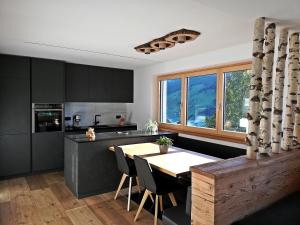 a kitchen with black cabinets and a wooden table at Nature luxury Chalet INSToul in Lutago