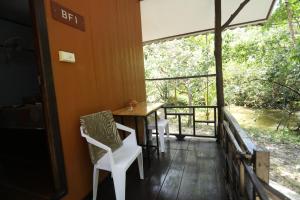 a room with a table and chairs and a window at Mata Guesthouse in Ko Kood