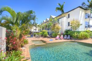 a swimming pool in front of a building at Cairns Queenslander Hotel & Apartments in Cairns