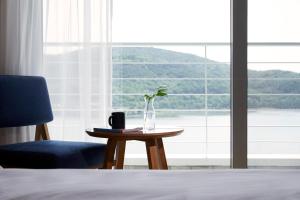 a vase with a plant on a table in front of a window at Lahan Select Gyeongju in Gyeongju