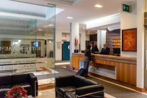 a lobby of a hotel with people standing at a counter at Hotel Royal Falcone in Monza