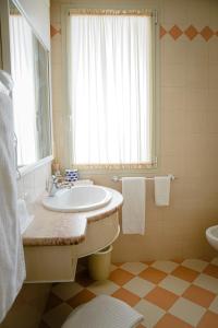 baño con lavabo y aseo y ventana en Hotel San Genesio en Fabbrico