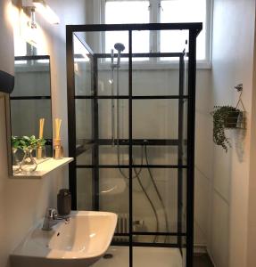 La salle de bains est pourvue d'une douche en verre et d'un lavabo. dans l'établissement Järnvägshotellet B& B i Skara, à Skara