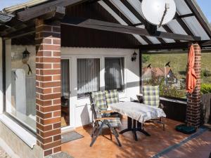 patio con mesa, sillas y ventana en Bright Holiday Home in Sch nbrunn with Garden en Langenbach