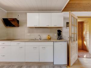 una cocina con armarios blancos y fregadero en Bright Holiday Home in Sch nbrunn with Garden en Langenbach
