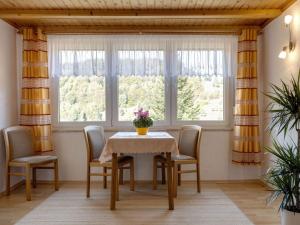 LangenbachにあるBright Holiday Home in Sch nbrunn with Gardenのダイニングルーム(テーブル、椅子、窓付)