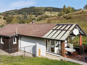 uma pequena casa branca com um telhado castanho em Bright Holiday Home in Sch nbrunn with Garden em Langenbach