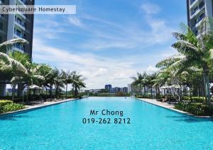 a large swimming pool with palm trees in a resort at Cybersqaure Studio Suites with Netfilx @10 min walking distance to McD in Cyberjaya