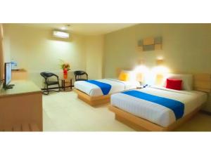 een hotelkamer met 2 bedden en een keuken bij Merpati Hotel in Pontianak
