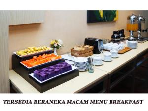 un buffet di cibo su un tavolo in camera di Merpati Hotel a Pontianak