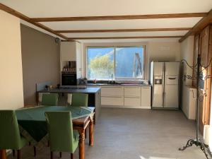 een keuken met een tafel, stoelen en een koelkast bij CASA MONTE DI SOPRA jacuzzi & sauna in Fanano