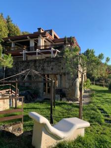 een huis met een witte bank in de tuin bij CASA MONTE DI SOPRA jacuzzi & sauna in Fanano