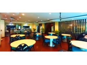 un restaurante con mesas y sillas y un bar en Merpati Hotel, en Pontianak