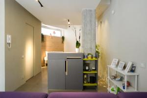 un soggiorno con frigorifero e divano viola di Exclusive Loft Salerno Centro a Salerno