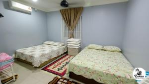 a bedroom with two beds and a rug at RIVERVIEW HOMESTAY PERLIS in Kangar