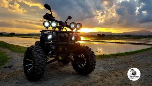 a motorcycle parked on a dirt road at sunset at RIVERVIEW HOMESTAY PERLIS in Kangar
