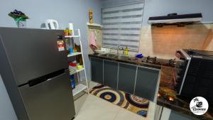 a kitchen with a sink and a refrigerator at RIVERVIEW HOMESTAY PERLIS in Kangar