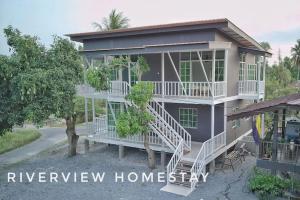 a large house with white stairs in front of it at RIVERVIEW HOMESTAY PERLIS in Kangar