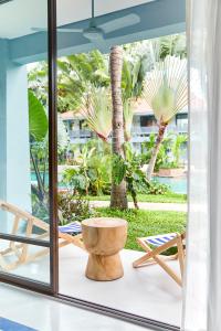 a room with a window with a chair and palm trees at The Peri Hotel Hua Hin - SHA PLUS in Hua Hin