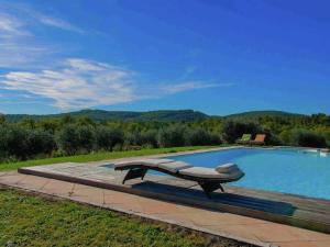 una piscina con un banco al lado en Belvilla by OYO Villa Sara, en Lucignano