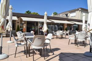 un grupo de mesas y sillas con sombrillas blancas en Camping Arena Blanca, en Benidorm